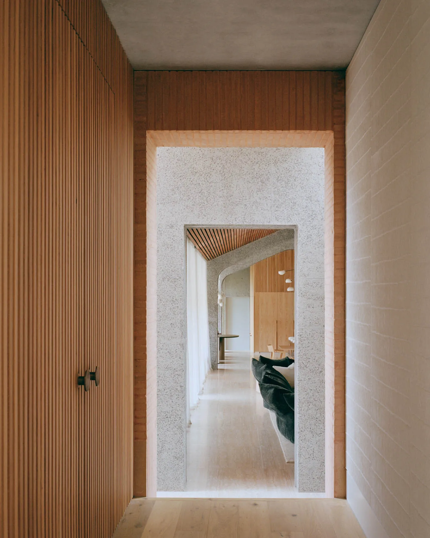 Modern entranceway featuring concrete walls and wooden elements.