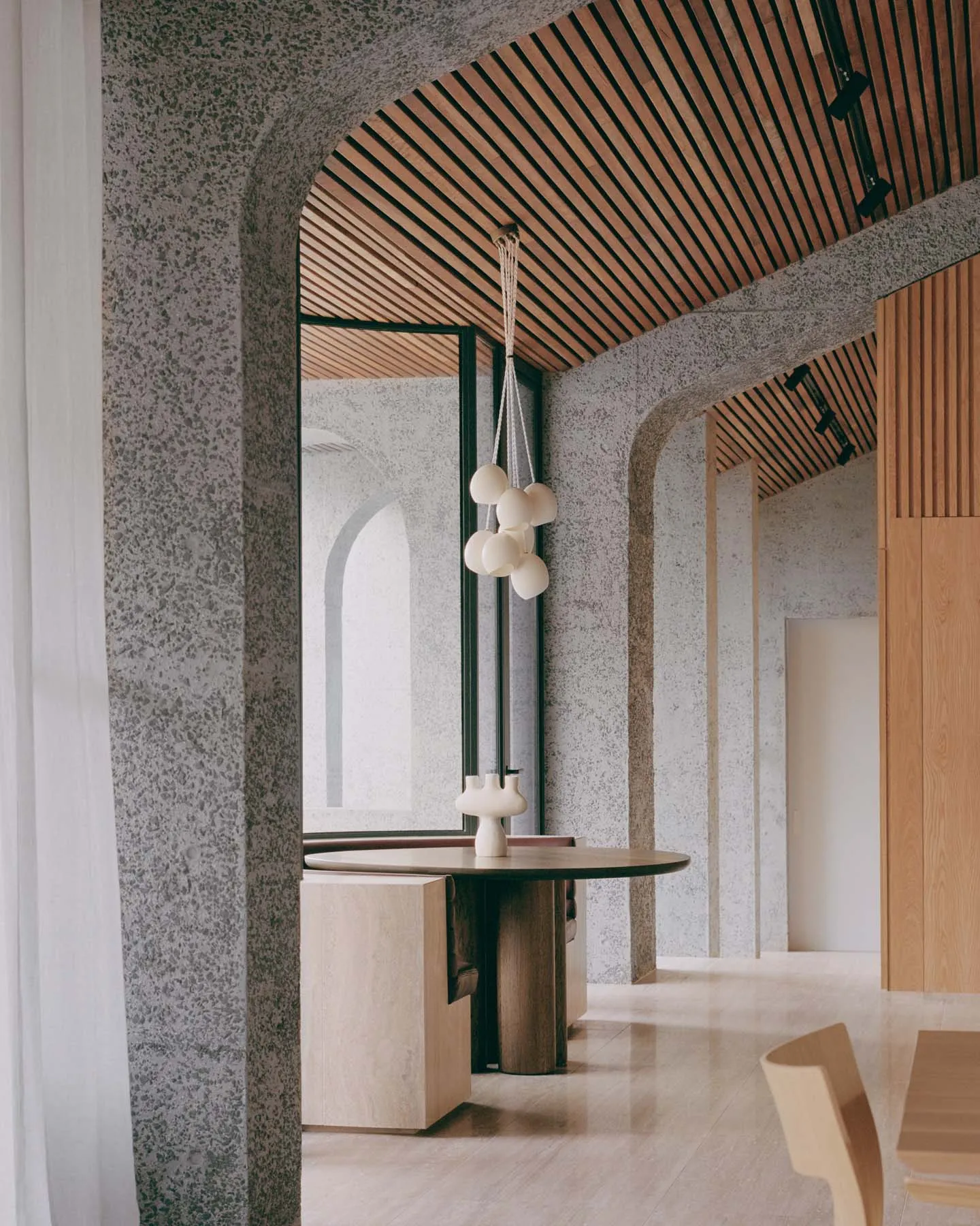 Modern industrial-style lobby with concrete walls and slatted wooden ceiling.