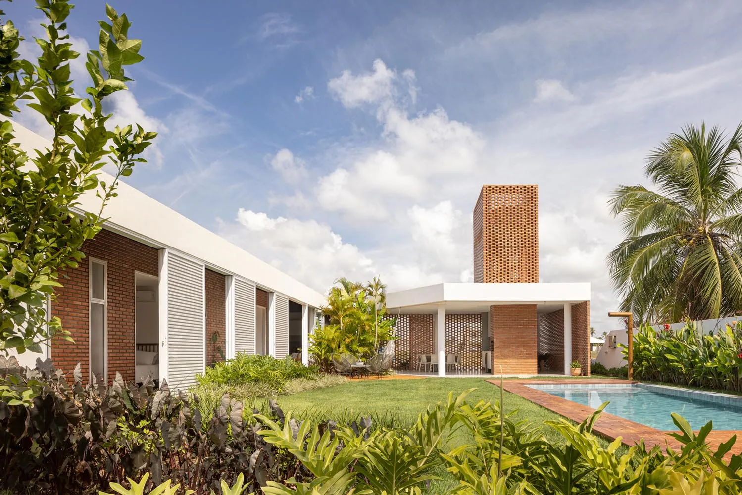 Modern residential exterior with brick chimney and concrete patio