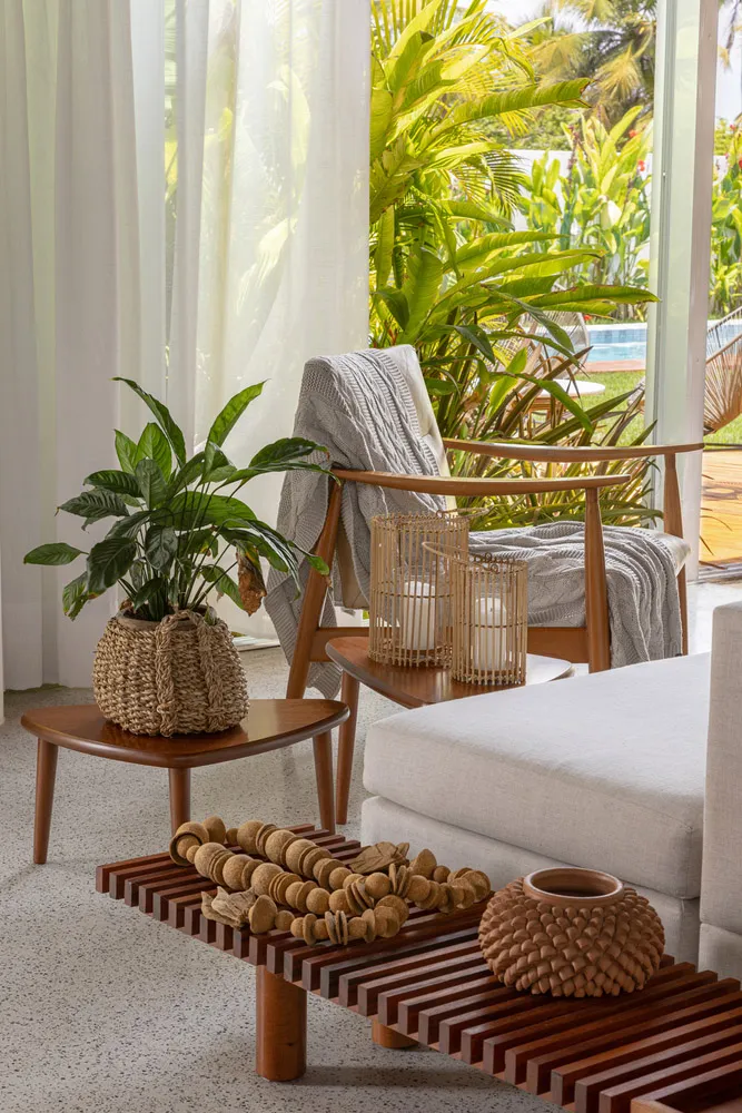A cozy mid-century modern living room with wooden furniture, green plants, and natural light streaming in.