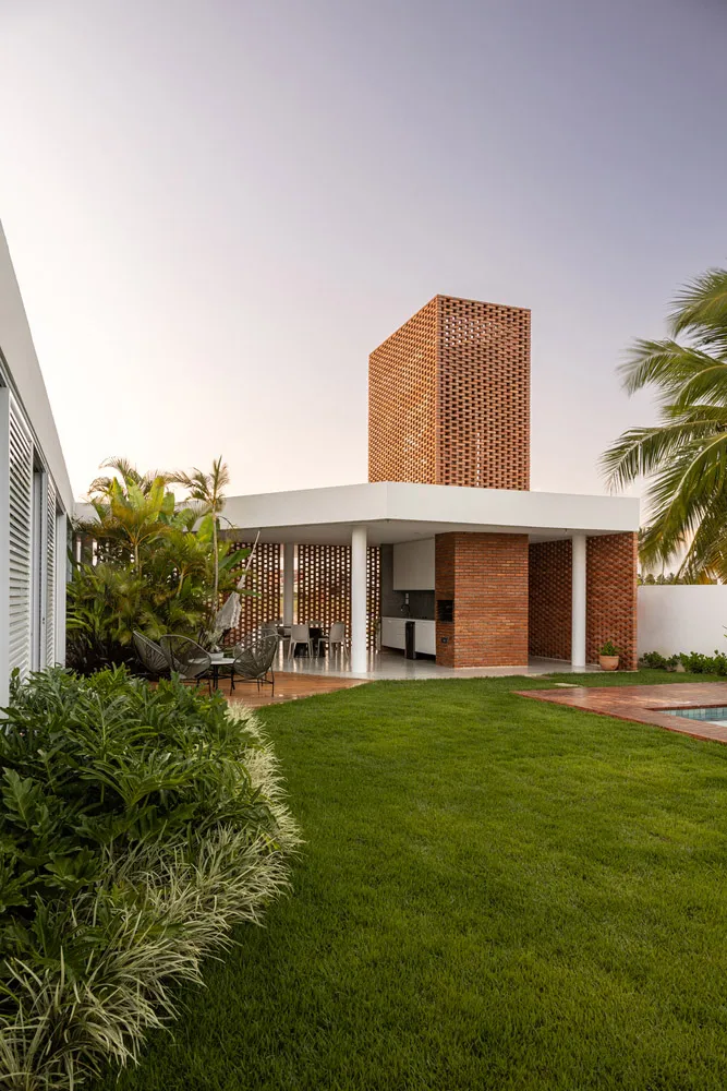 Modern residential exterior of a house featuring brick walls, glass windows, and wooden elements.