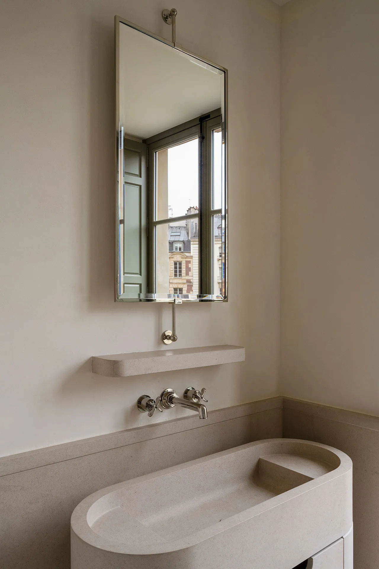 Modern bathroom featuring a sleek, minimalist concrete sink with a large mirror above it.