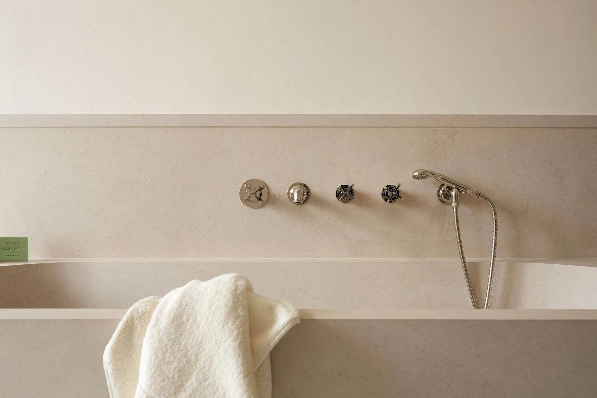 Modern bathroom with a minimalist design featuring a concrete bathtub and sleek, chrome fixtures.