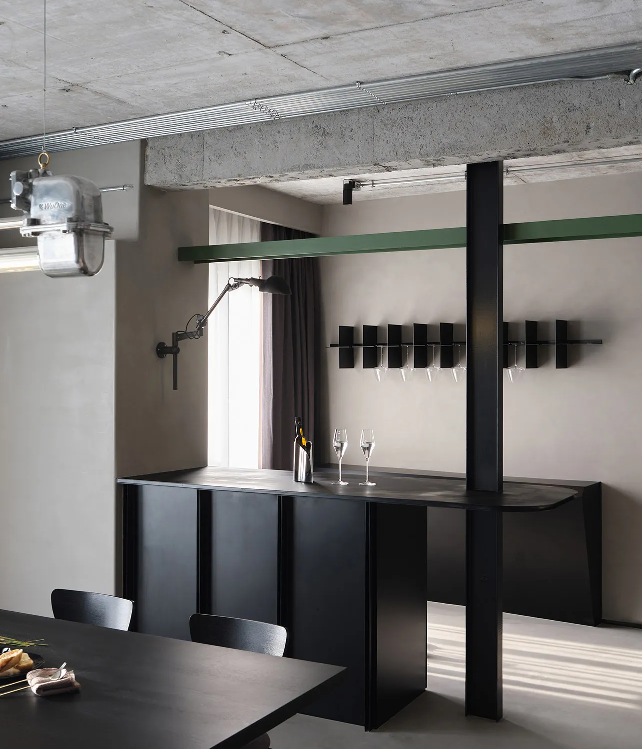 Industrial-style bar with dark metal counter and green trim.