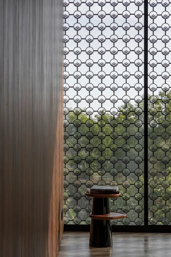 A modern interior featuring decorative metal screens with intricate circular patterns.