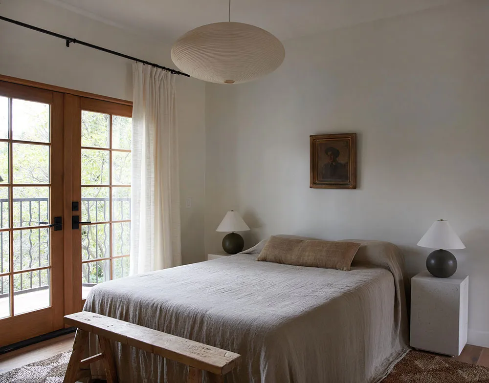 A minimalist bedroom with a bed made of cotton and linen blend sheets.