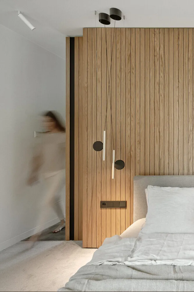 Minimalist bedroom design featuring wood accent wall and bed
