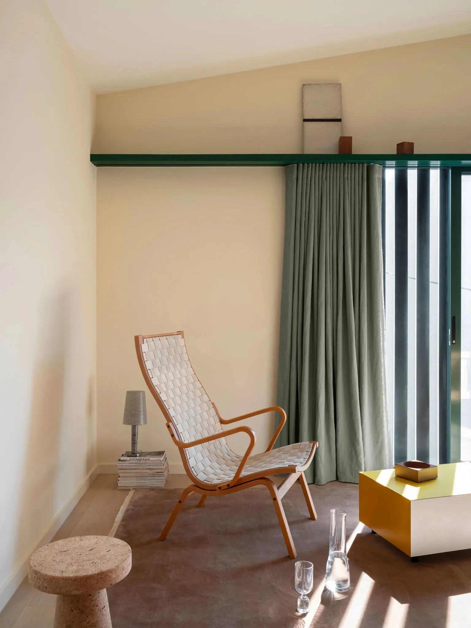 Modern living room with woven fabric armchair, green curtains, and wooden floor.
