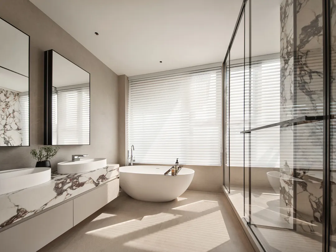 Modern bathroom featuring a freestanding tub, double sinks, and marble accents.