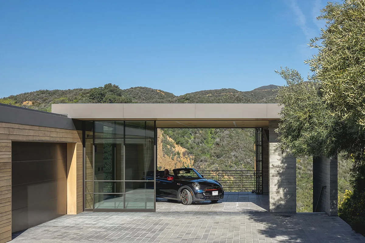 A modern residential exterior featuring concrete and glass materials.