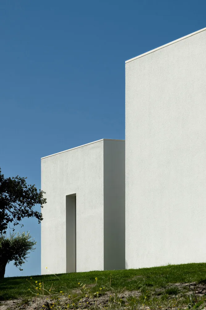 A minimalist white building made of concrete materials.