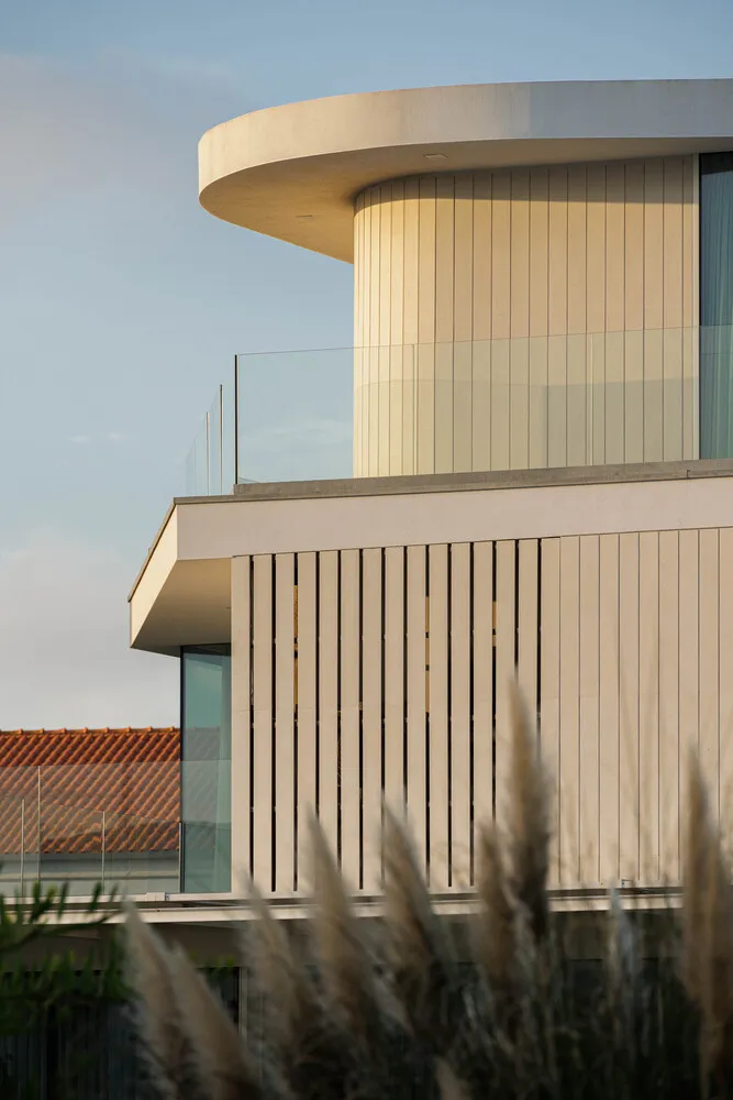 Modern residential exterior featuring a glass and concrete design.