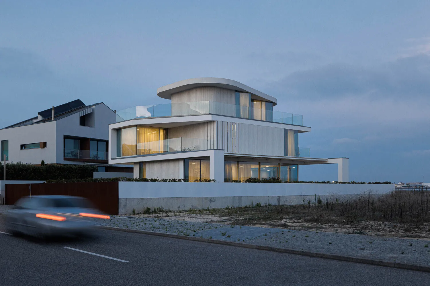 Modern residential exterior featuring white panels and glass.