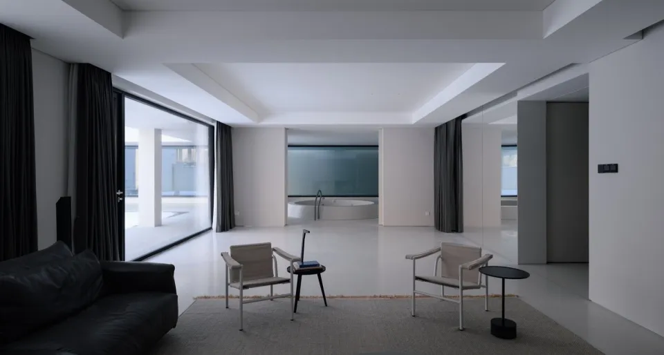 Modern minimalist living room with concrete flooring, large glass windows, and a black sofa
