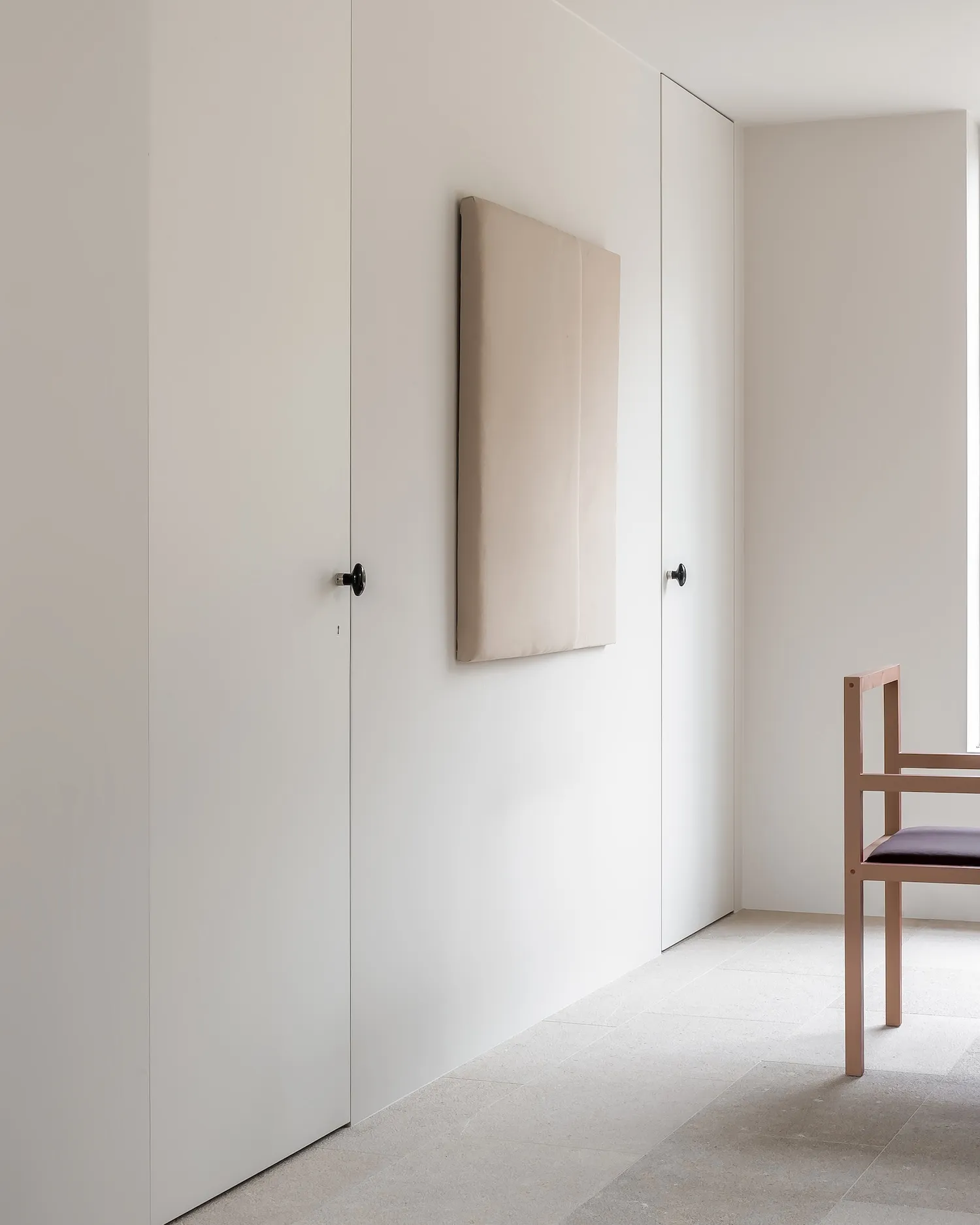 A minimalist interior space featuring concrete walls and furniture.