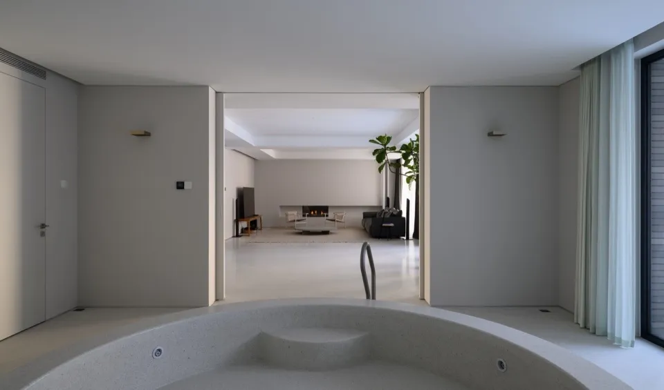 Modern living room with concrete floor, fireplace, and minimalist design.