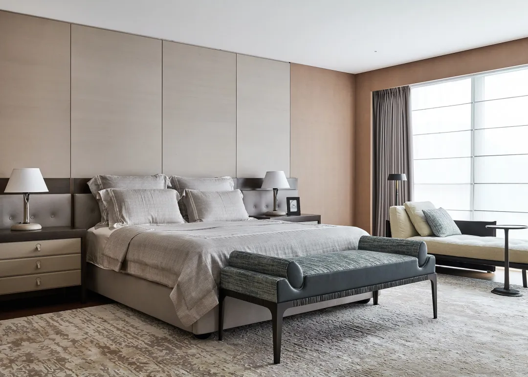 Modern minimalist bedroom with fabric bedding, wooden headboard, and metallic accents.