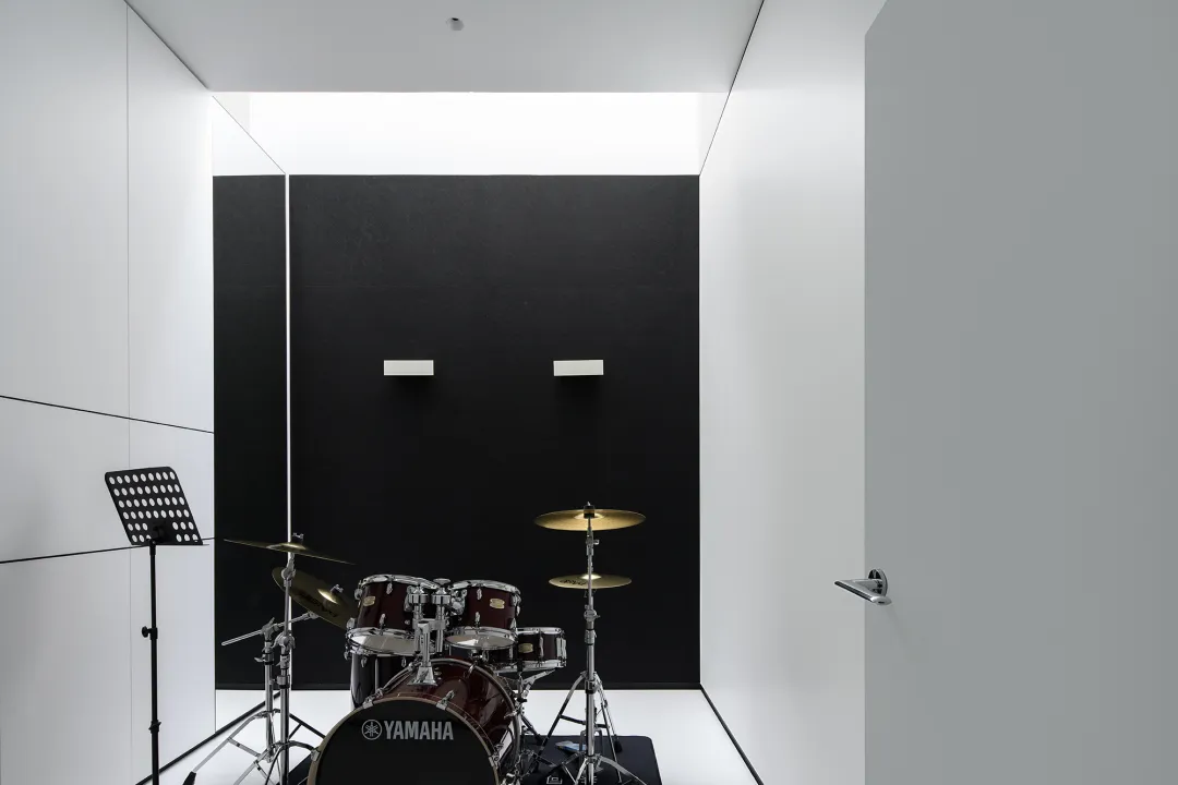 簡約音樂室內有黑色吸音泡棉牆面與 Yamaha 鼓組。