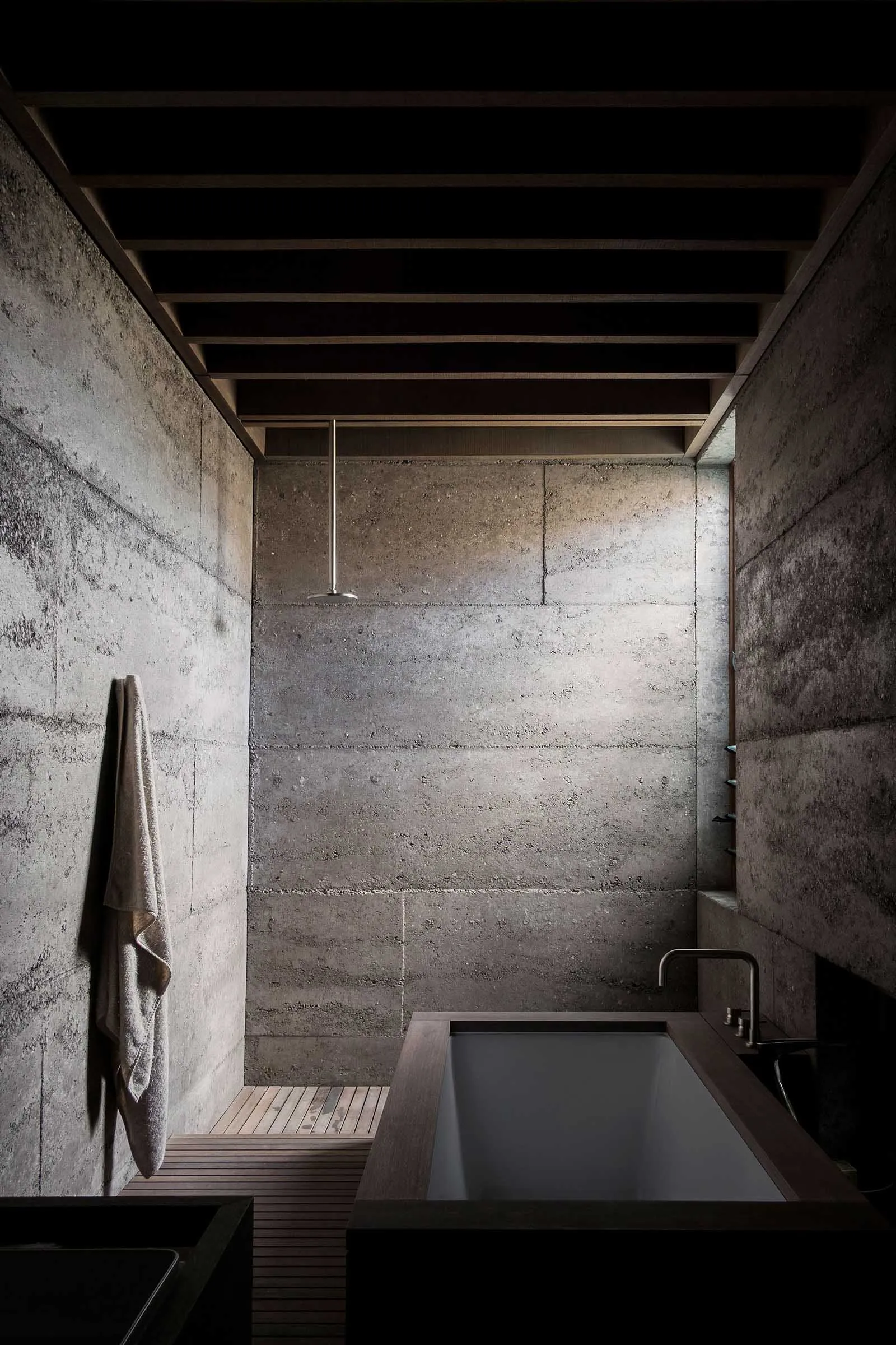 Concrete bathroom with industrial design elements, including exposed beams and minimalist fixtures.
