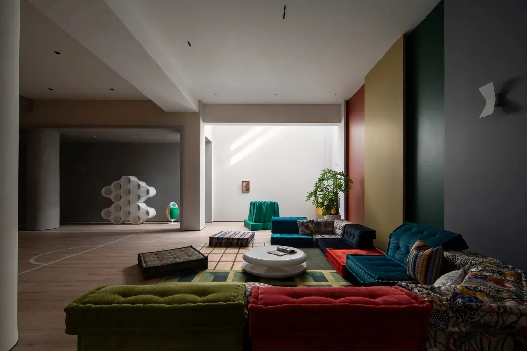 A modern, colorful living room with a variety of furniture and decorative elements.