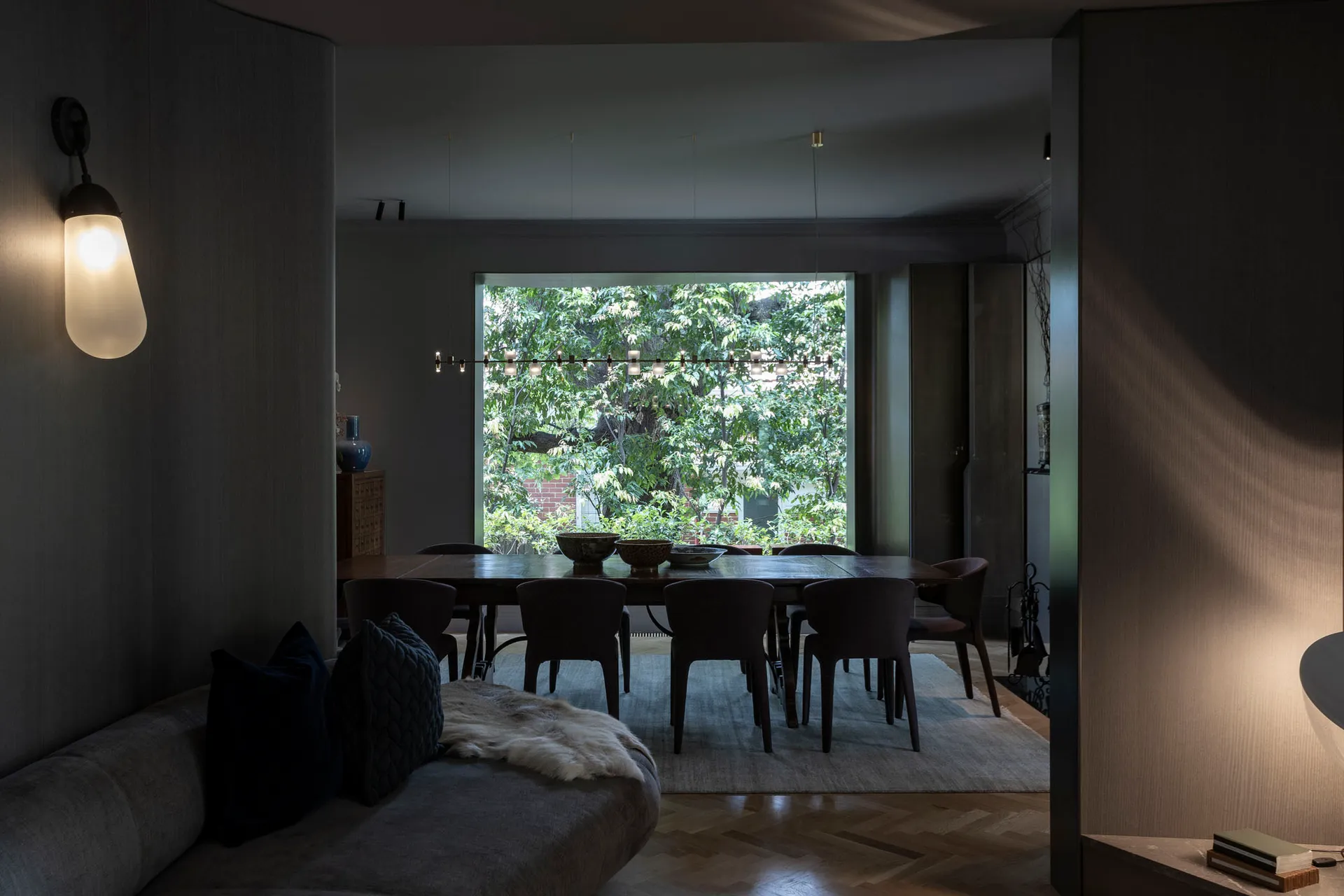 Modern dining room featuring leather chairs and a glass dining table surrounded by a cozy seating area.