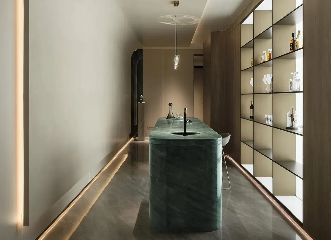 Modern interior design featuring a sleek marble bar counter and illuminated shelves.