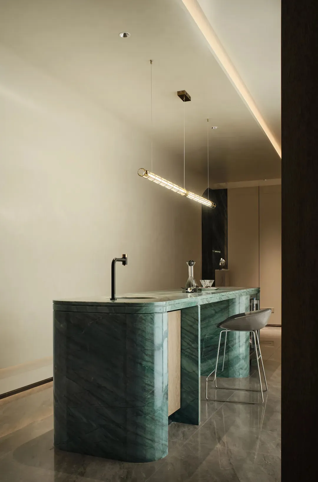 Modern kitchen with green marble countertops and black faucet