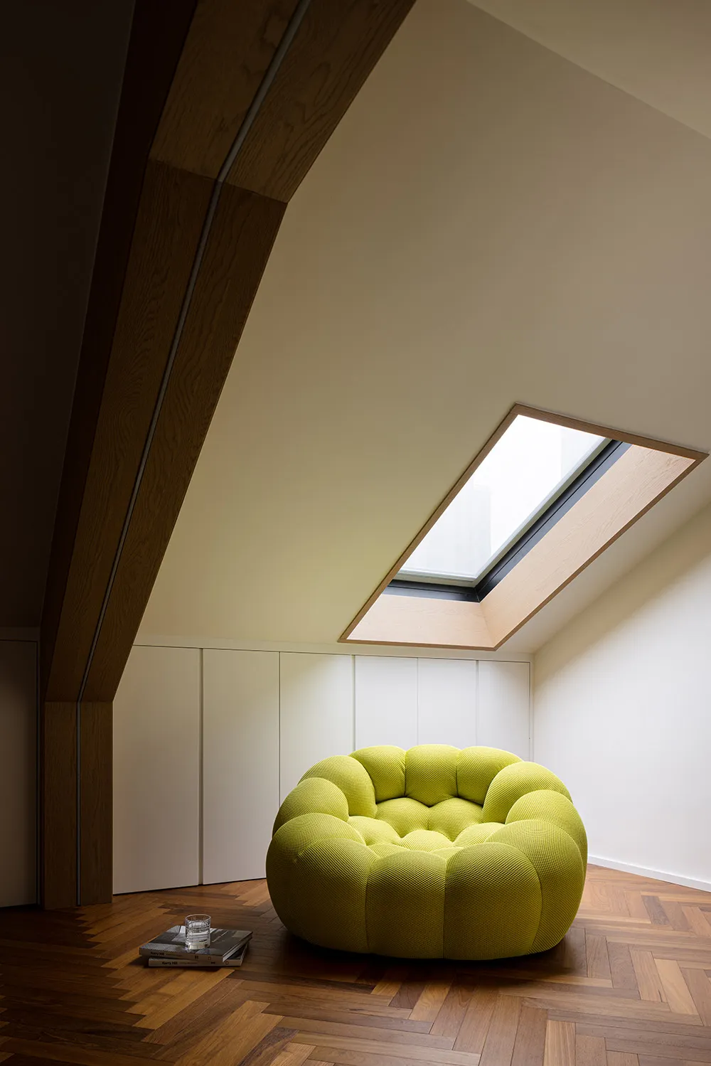 A modern loft featuring a round, yellow, pouf-style sofa in a personal space