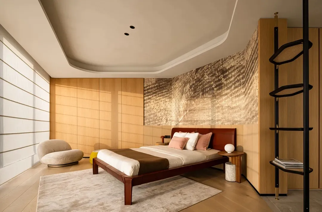 A modern bedroom featuring minimalist furniture and a wooden headboard with a fabric bedspread.