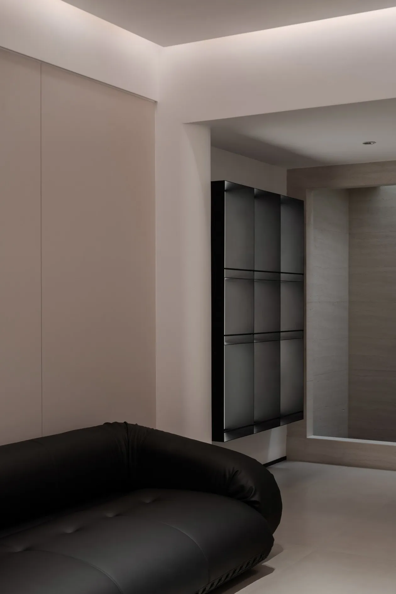 Modern minimalist living room featuring a glass cabinet and a sleek black sofa.
