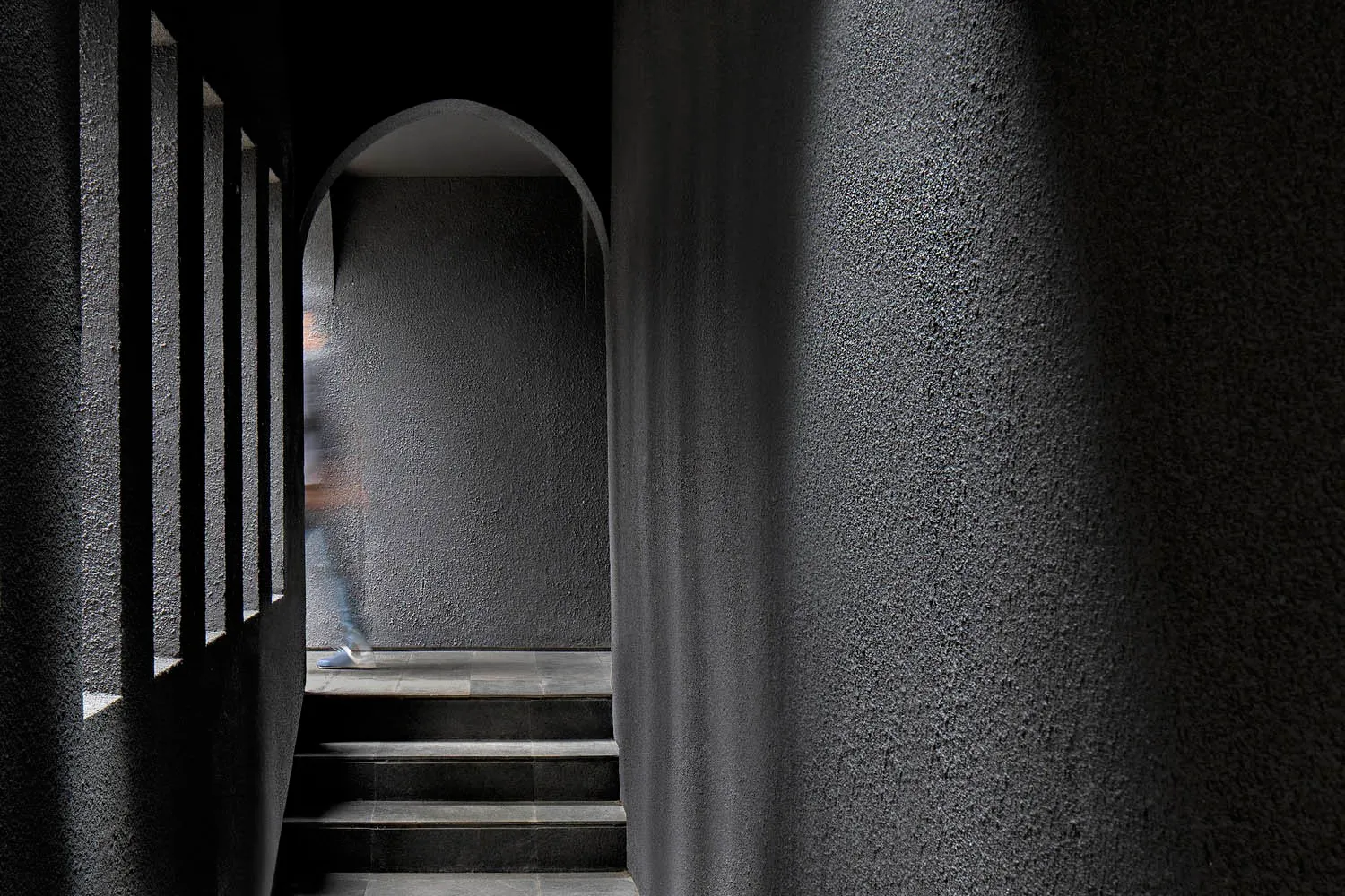 A modern staircase constructed from concrete, with a minimalist design and a single step visible.