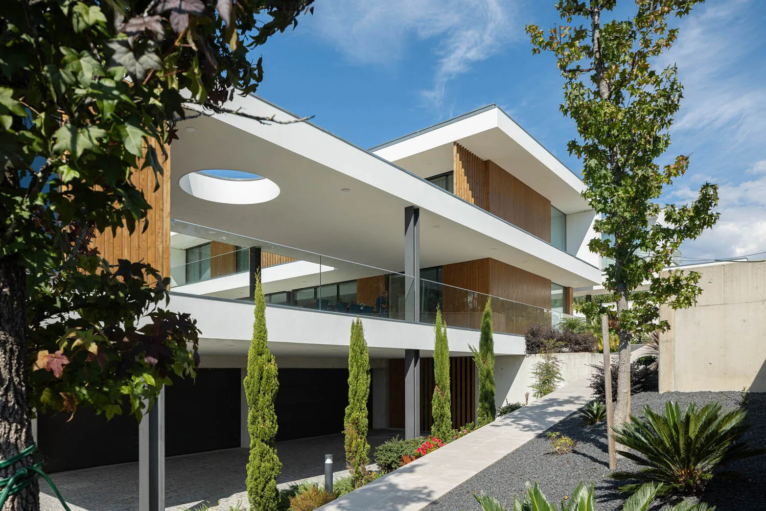 Modern residential building featuring concrete, glass, and wood materials.