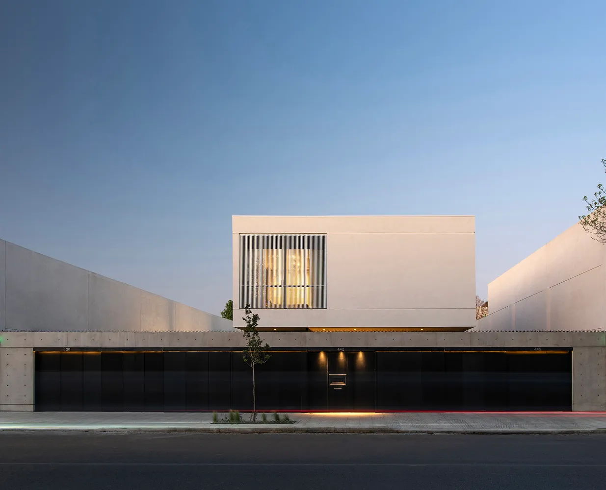 Modern concrete building with large windows and minimalistic design.