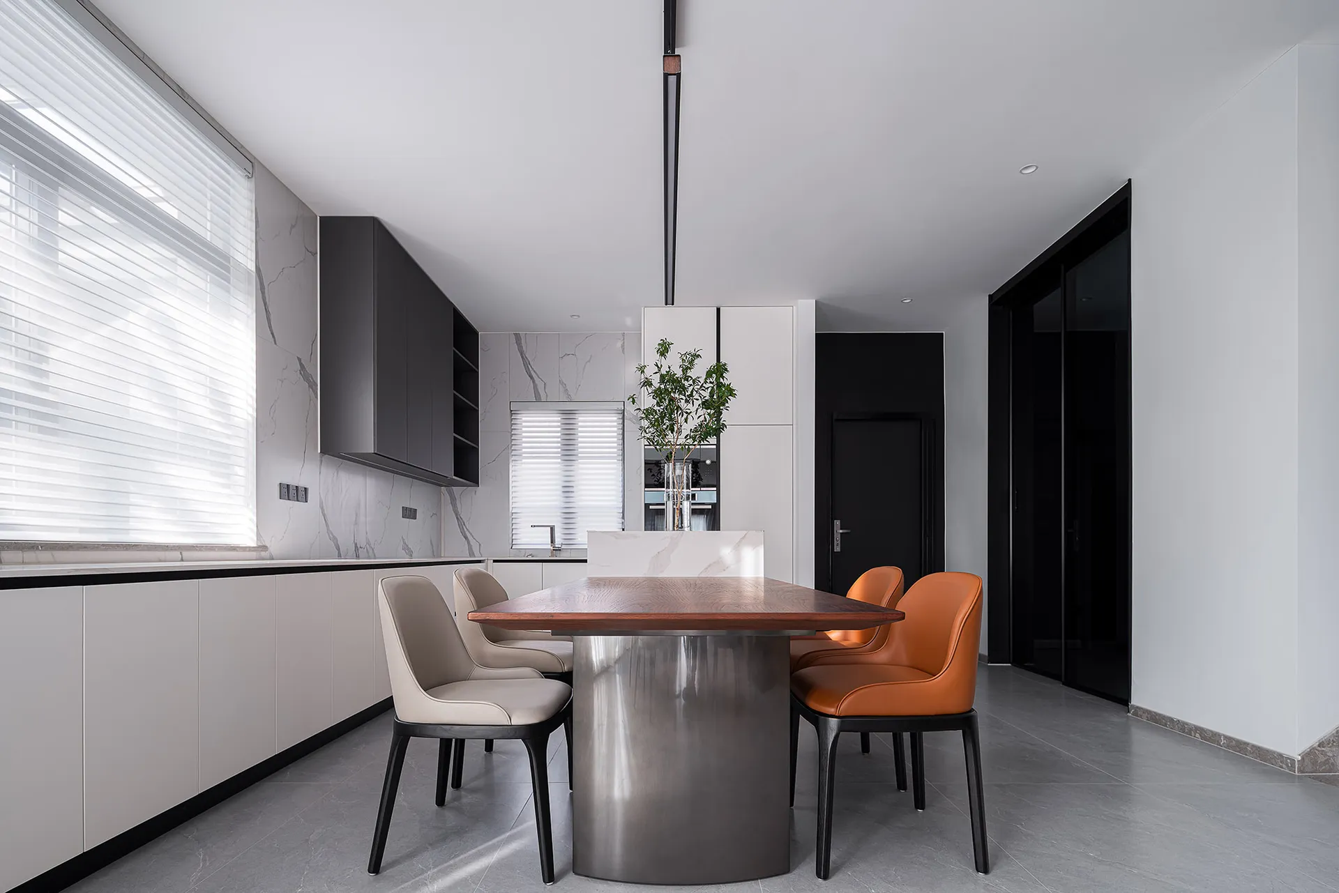 A modern kitchen and dining room featuring a combination of metal and wood furniture.