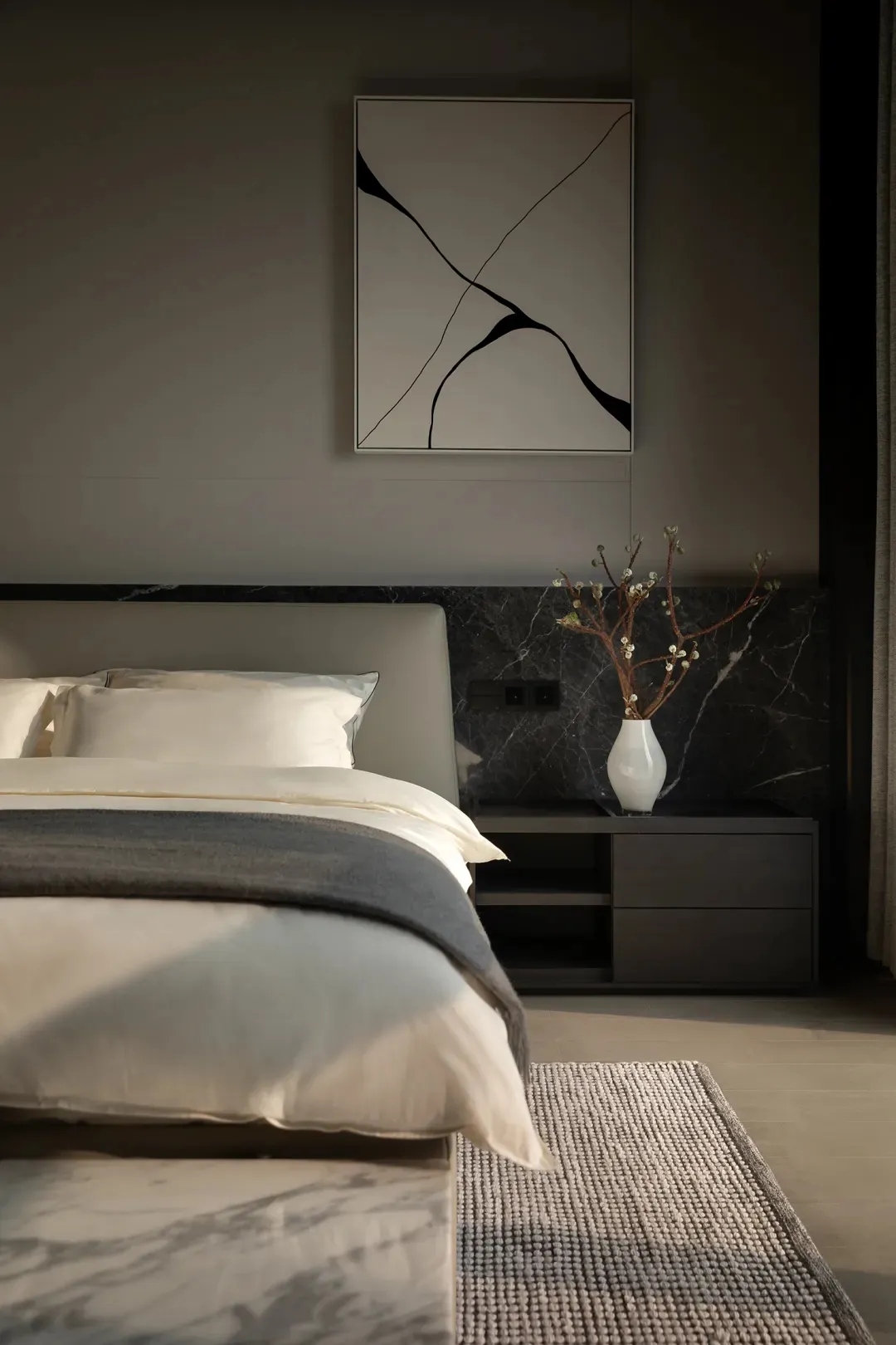 Minimalist bedroom with a bed, nightstand, and abstract art.