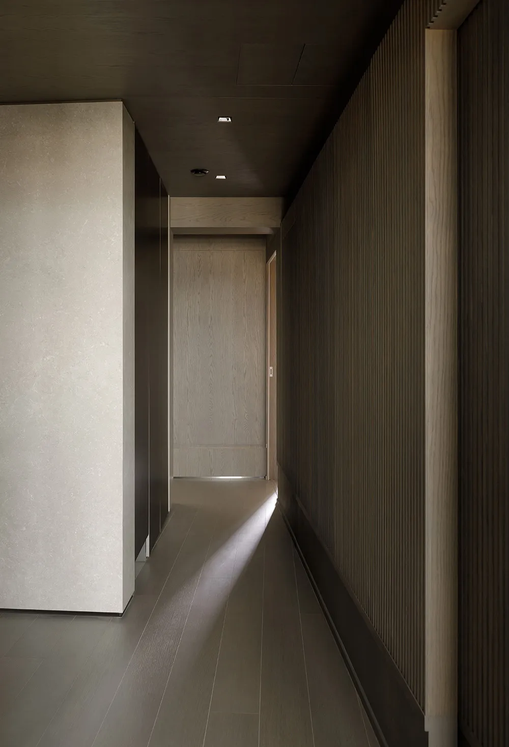 A modern corridor featuring wooden flooring and minimalist design elements.