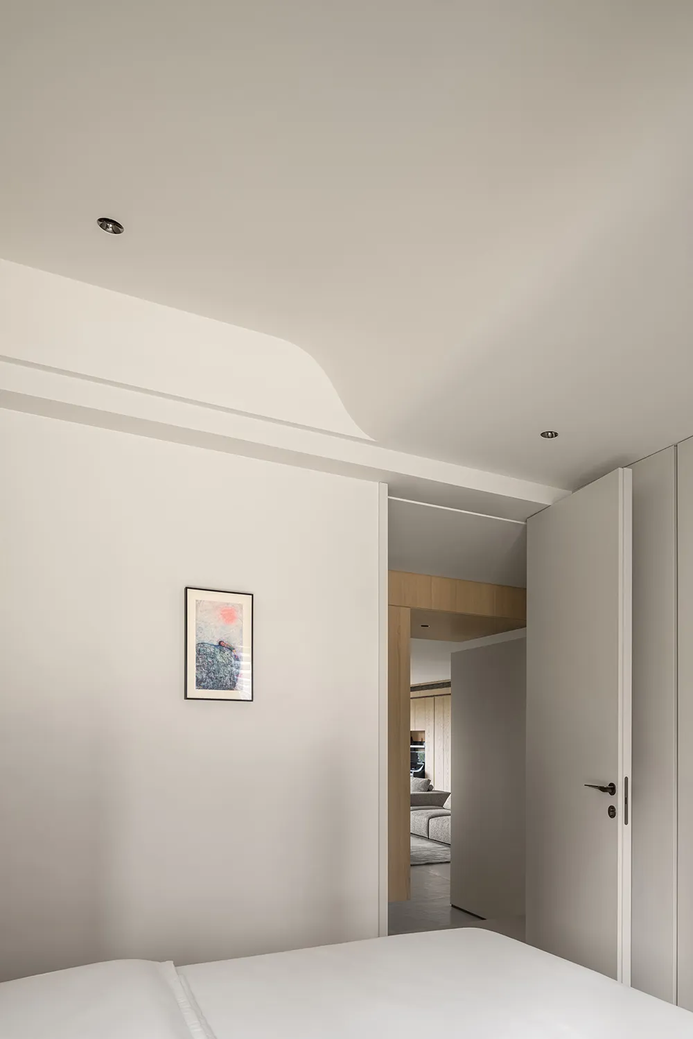 Modern minimalist bedroom with white matte furniture and a wall art