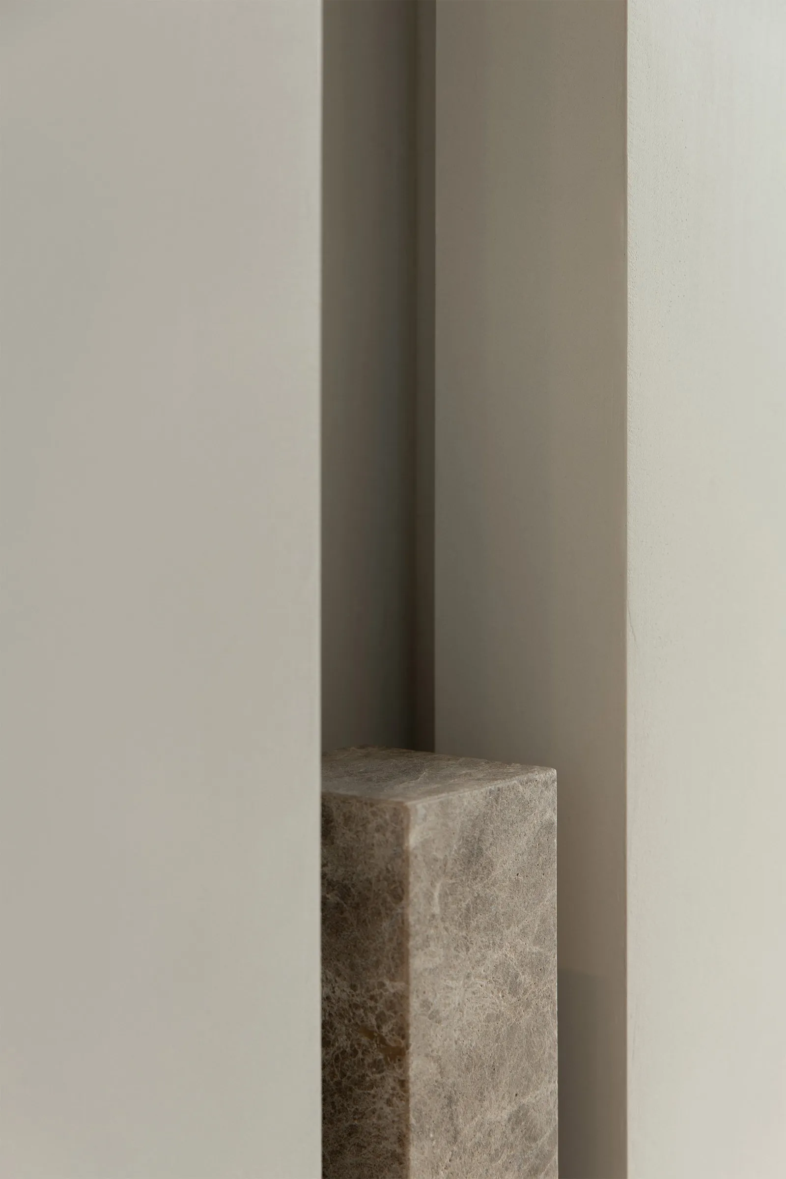 Close-up image of a modern interior concrete column against a plain wall background.