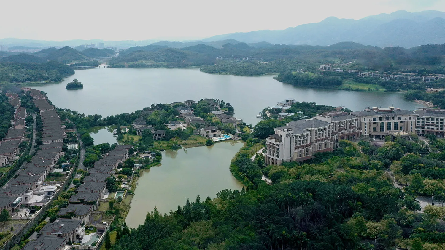 俯瞰現代住宅建築，周圍環繞大湖與綠意。