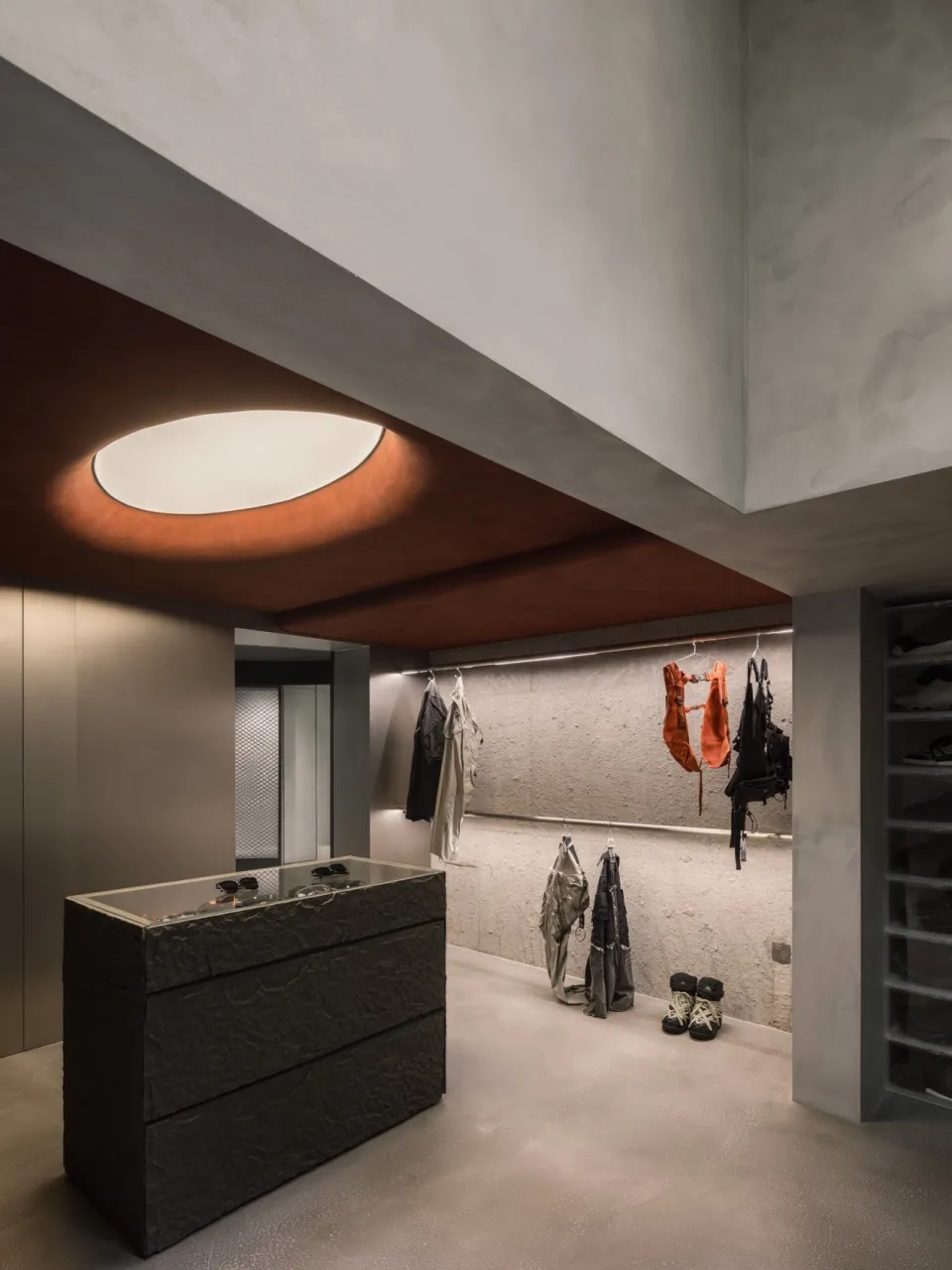 Modern industrial clothing retail store interior with concrete walls and minimalist design.