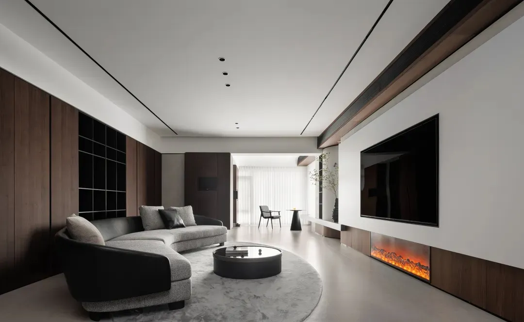 現代簡約客廳，配有大型黑白沙發、黑白圓形咖啡桌，以及大型電視