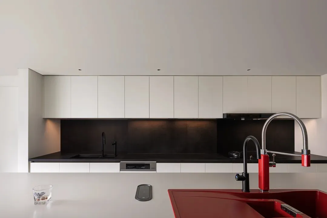 A modern kitchen featuring a black countertop and sleek stainless steel appliances.