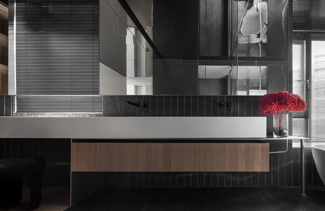 Modern minimalist bathroom with dark metallic black tiles and metallic accents, featuring a sleek floating vanity with wooden