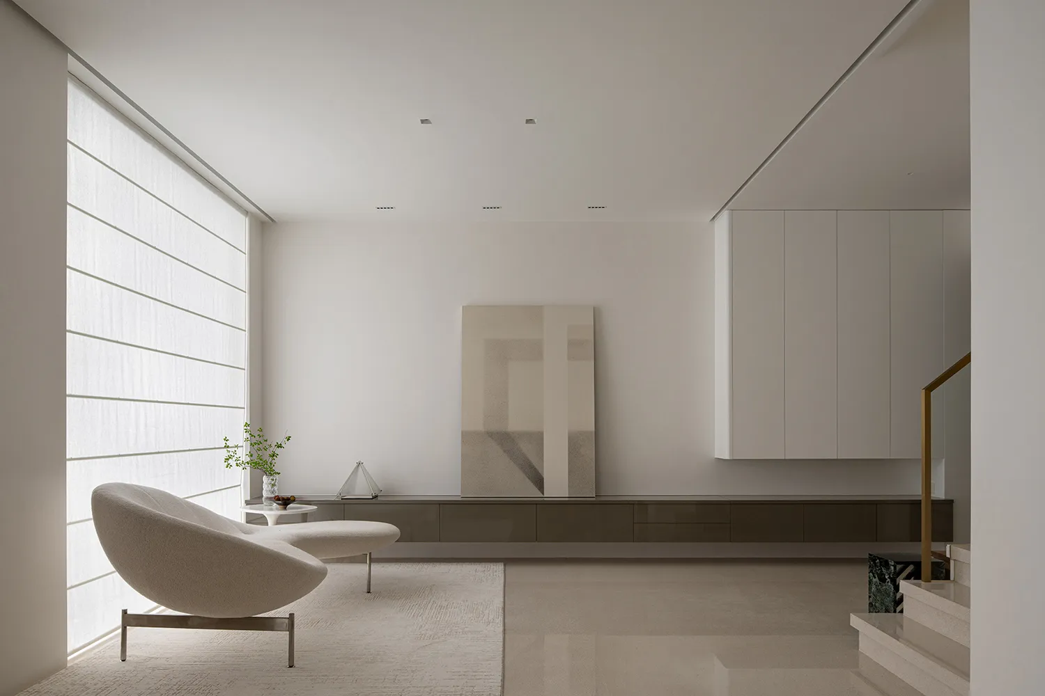 A living room with minimalist design featuring concrete and glass elements.