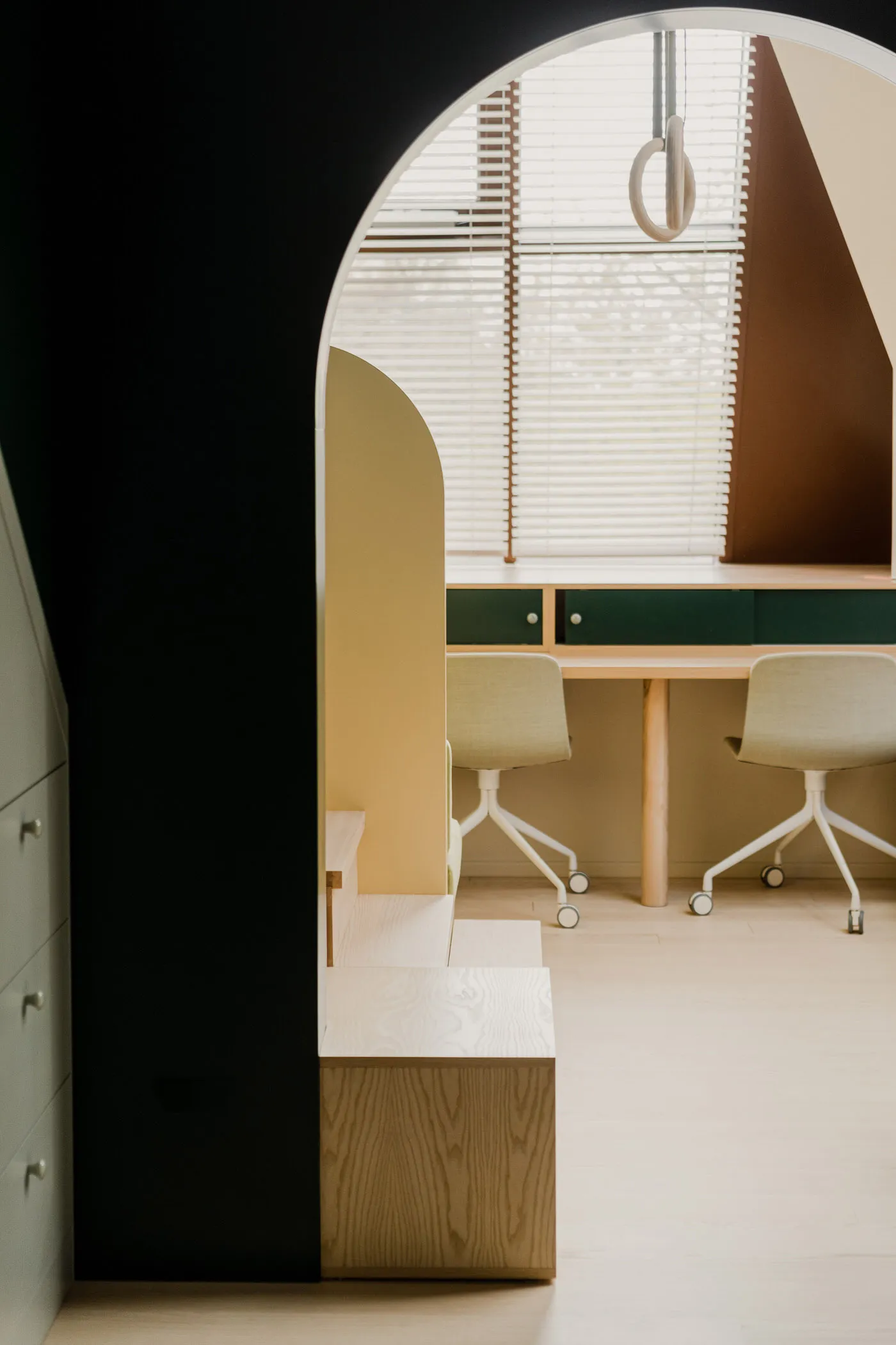 A modern office interior featuring minimalist design principles, with a combination of wood and glass materials, and upholste