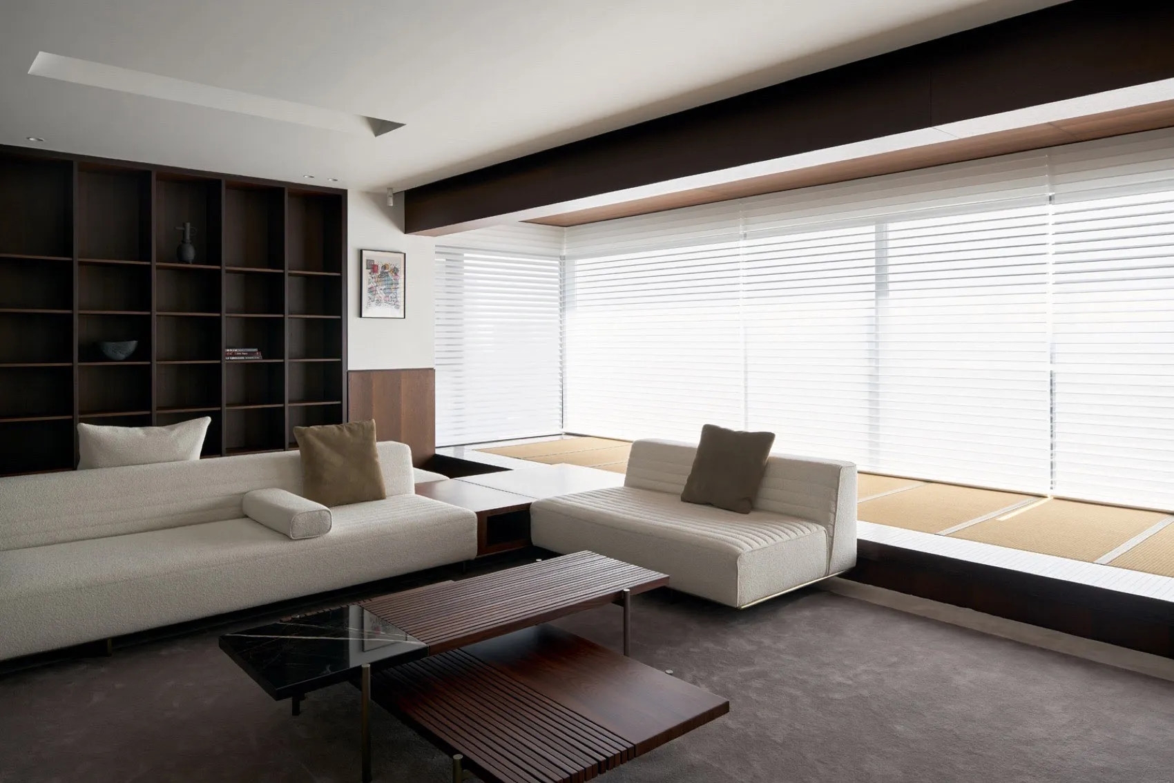 A minimalist living room with concrete furniture and large windows.