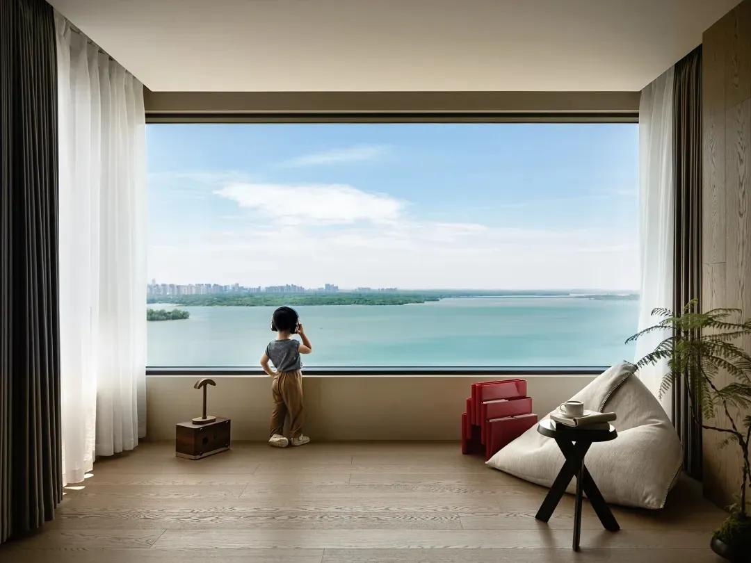Minimalist living room featuring a large window with a view of the water, equipped with wood flooring and cotton blinds.