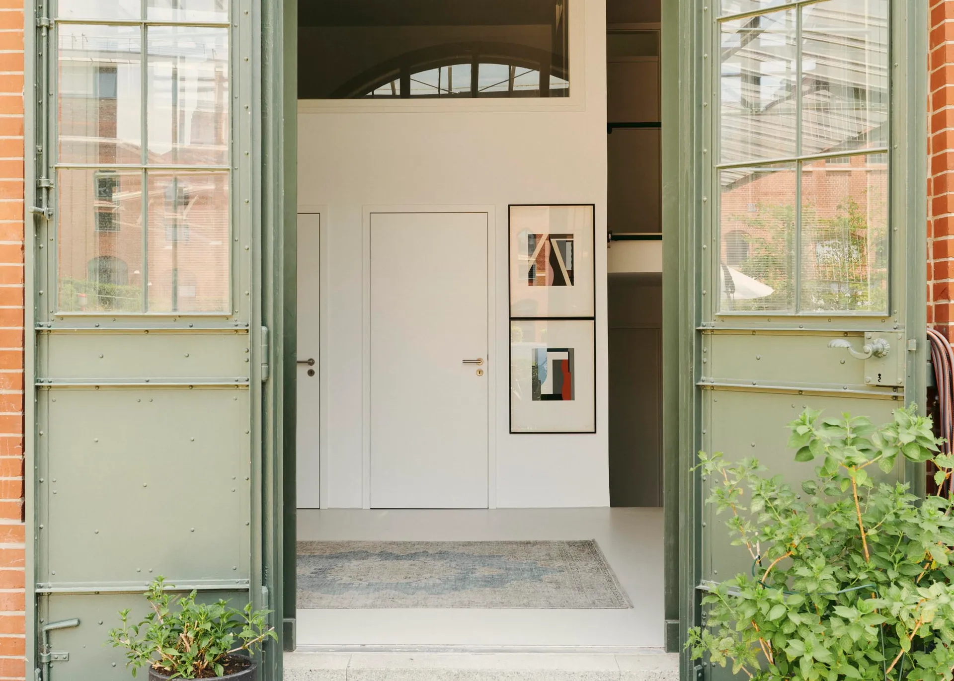 Modern minimalist entrance with concrete floor and framed artwork.