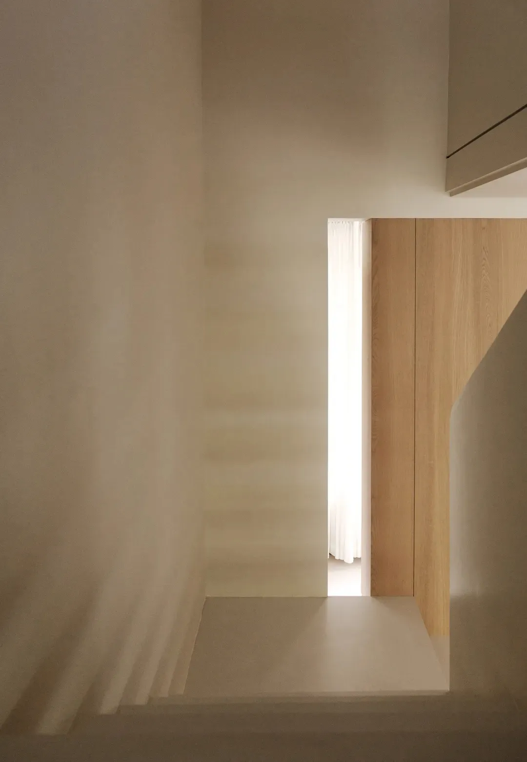 A minimalist interior space with a wooden and white color palette.