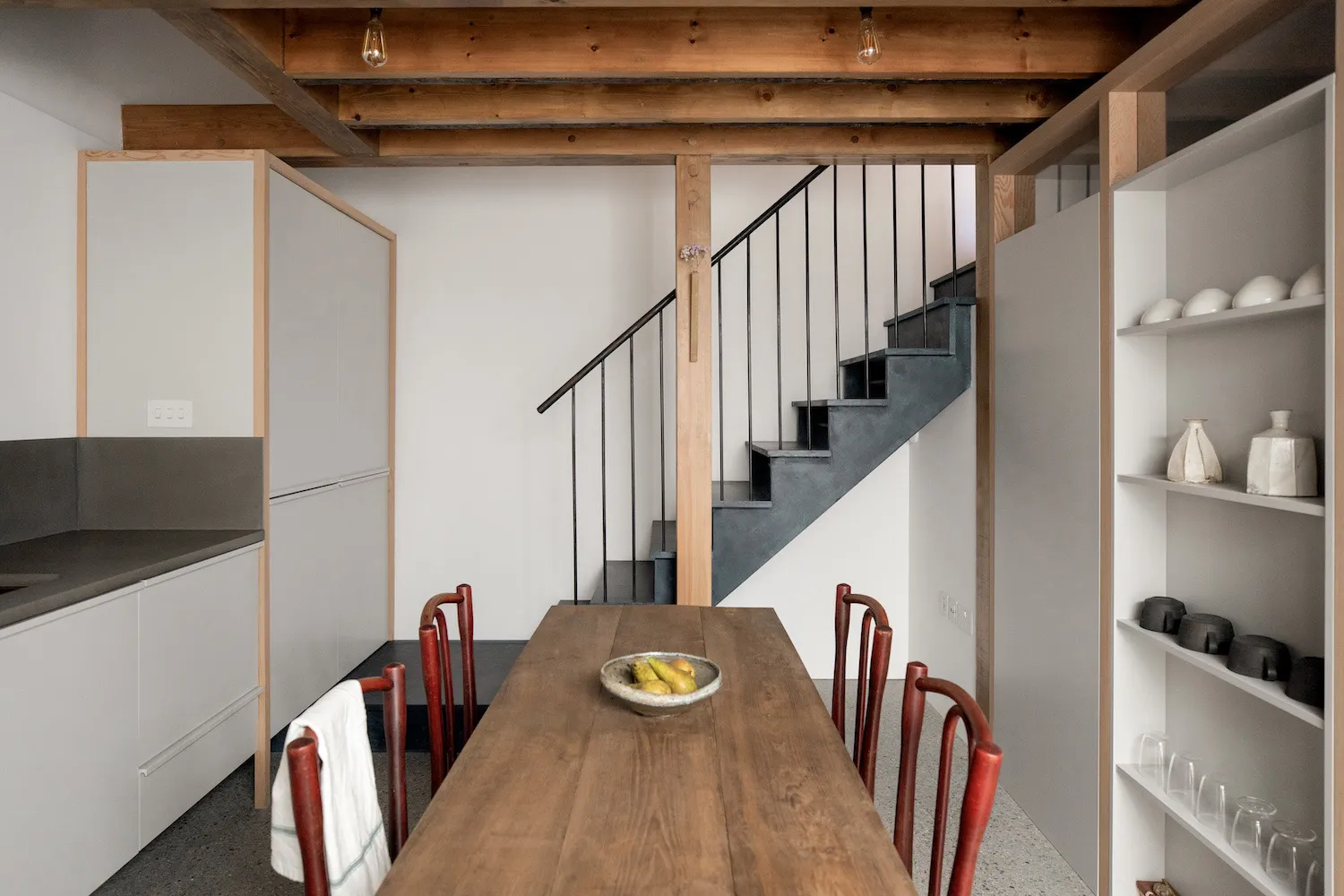 A modern kitchen with wooden elements and white cabinets.